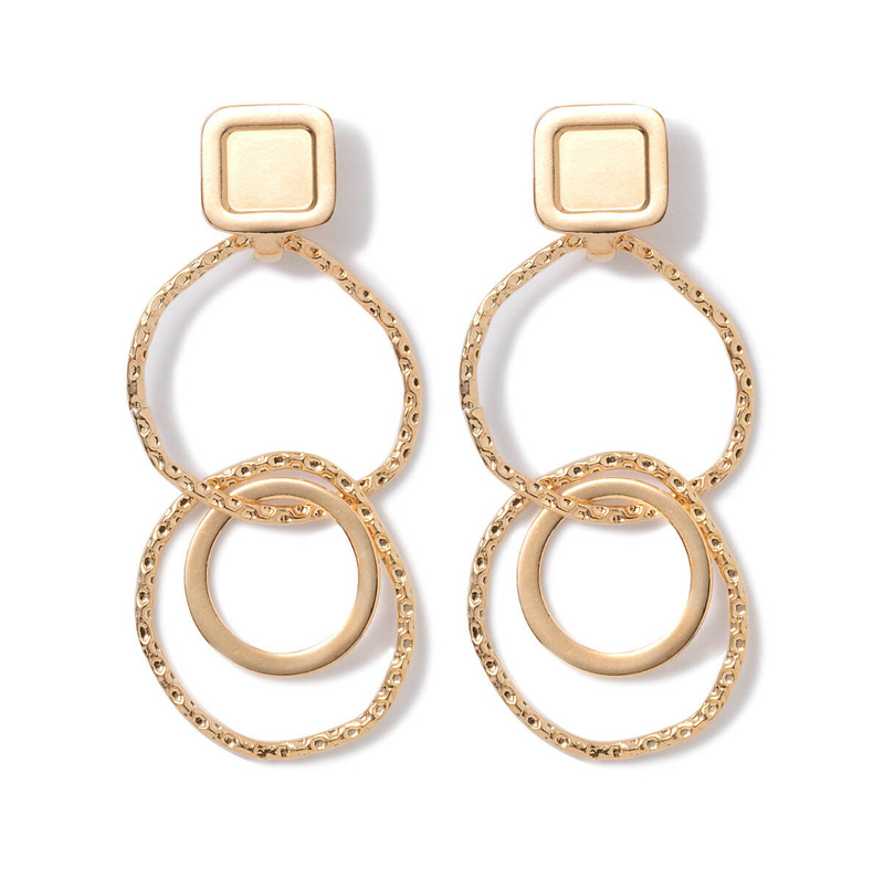 Kolczyki składające się z kółek o rożnym kształcie i surowym wykończeniu