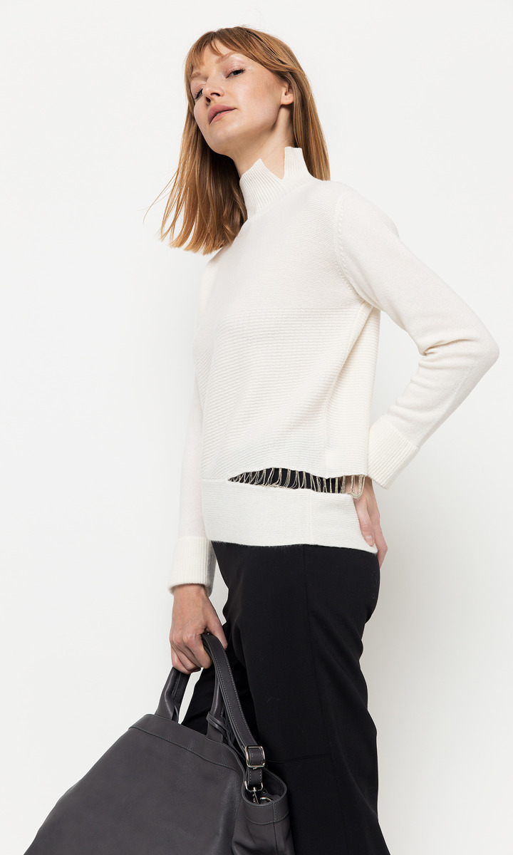 Biały, kaszmirowy sweter z rozcięciem ozdobionym delikatnymi łańcuszkami