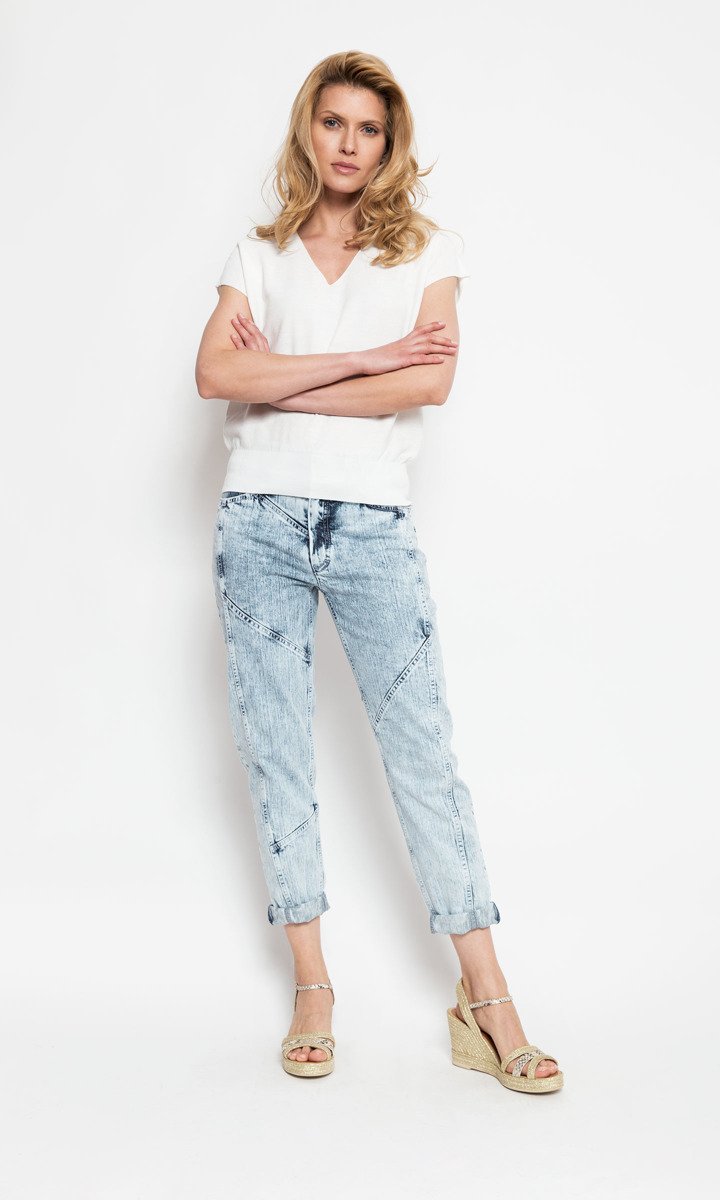 Luźne, jeansowe spodnie jasno wybarwione z ciąciami na nogawkach oraz grubą gumą w talii